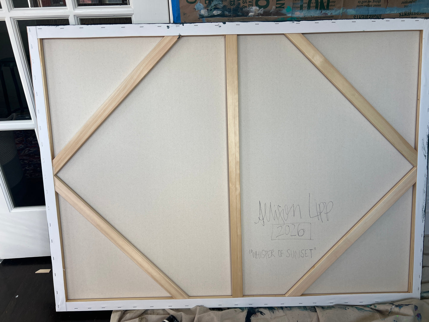 Large white canvas with geometric wood frame on a black surface