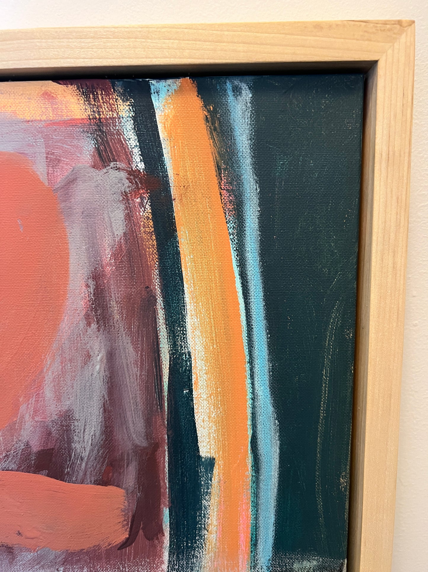 Abstract painting with orange, black, and white strokes in a wooden frame.