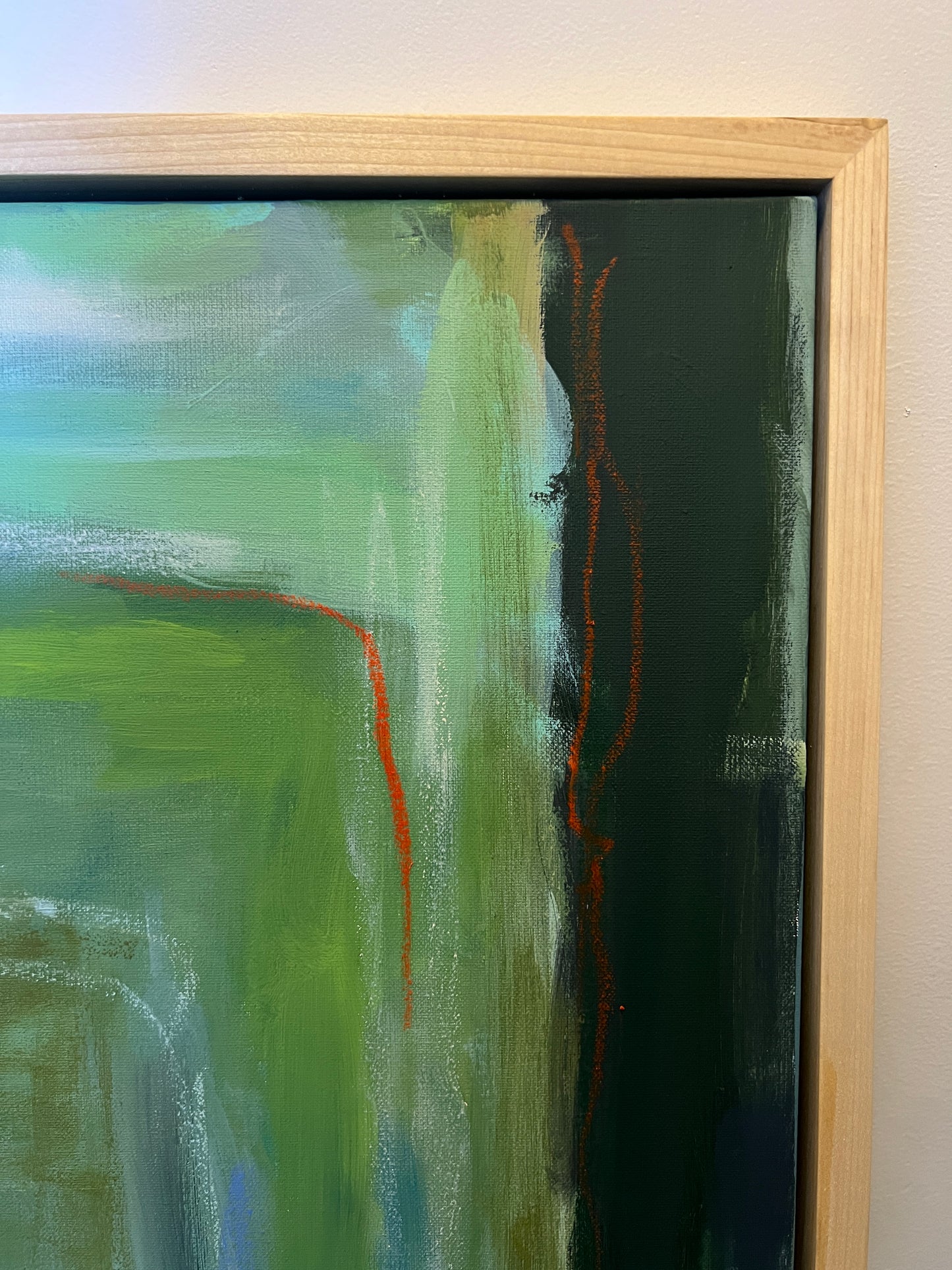 Abstract painting with green and red strokes in a wooden frame.